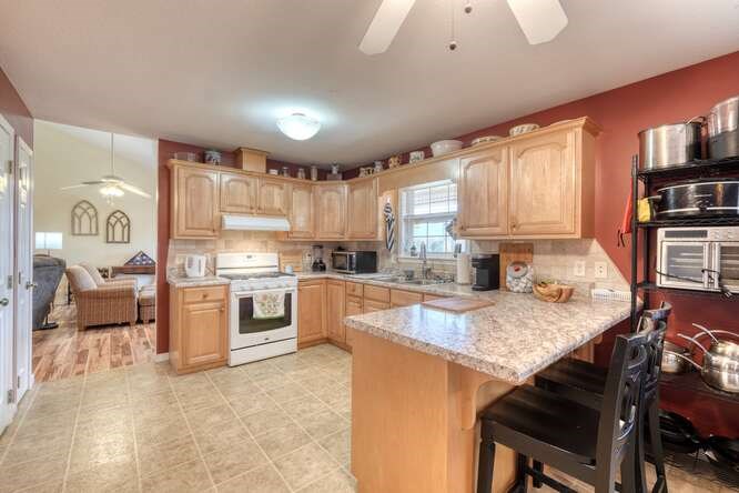 756 Doc Jones Road Blairsville, GA 30512 - Photo 25 of 46 a kitchen with a stove a sink a kitchen island and chairs in it