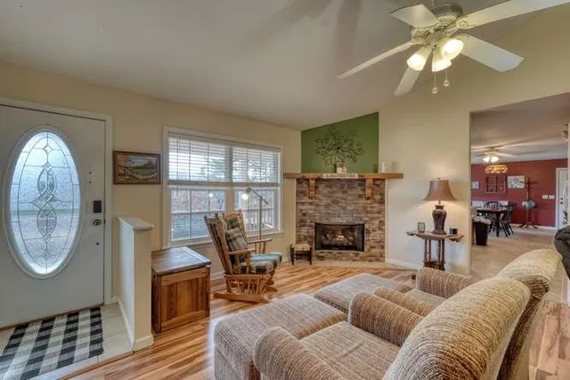 a living room with furniture a fireplace and a floor to ceiling window