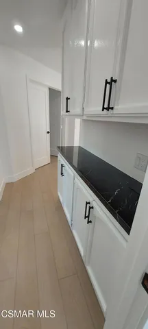 a kitchen with granite countertop a sink a stove and cabinets