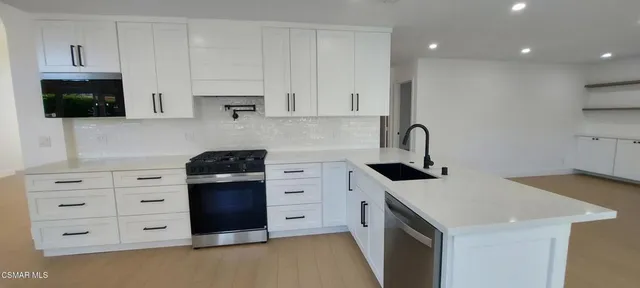 a kitchen with stainless steel appliances a stove microwave and cabinets