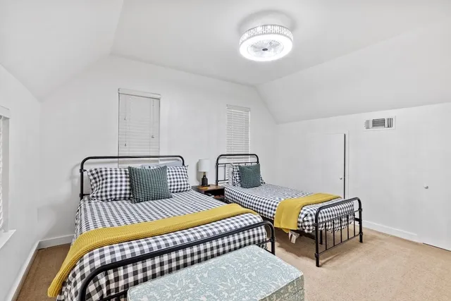 a bedroom with two beds and ceiling fan