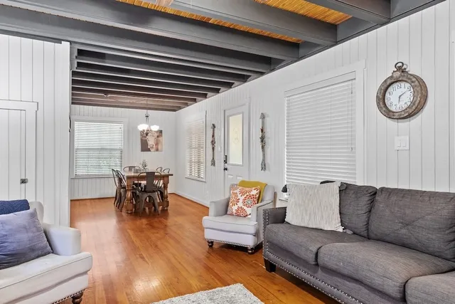a living room with furniture a clock on wall and a window