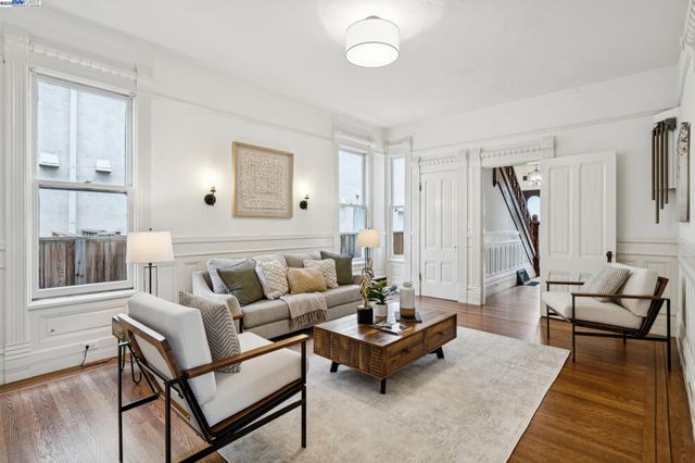a hallway with white cabinets and wooden floor