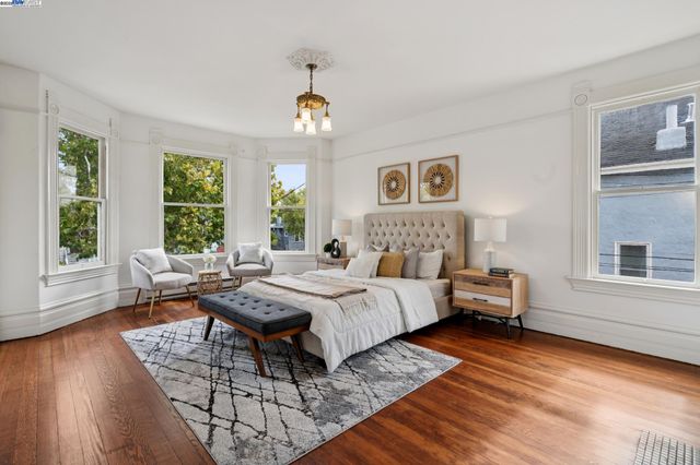 a bedroom with a bed couches and wooden floor