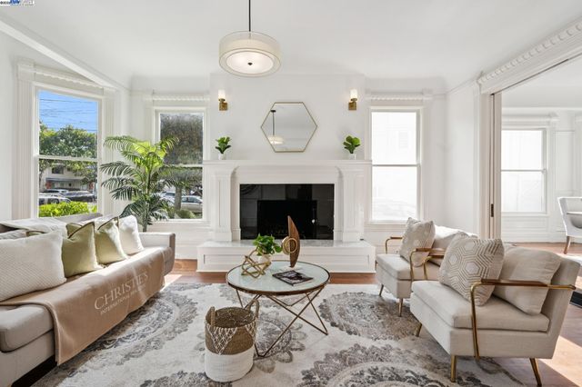 a living room with furniture a fireplace a clock and a large window