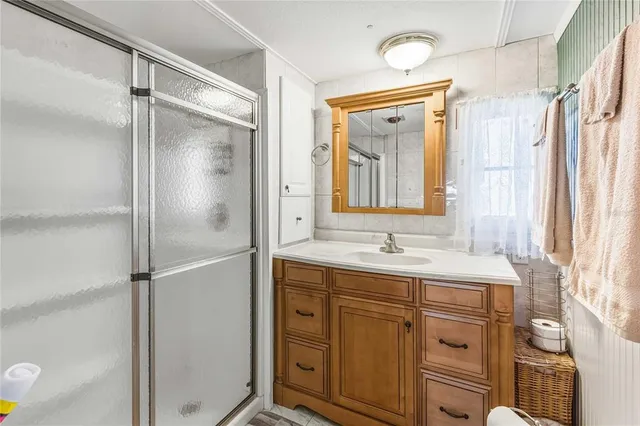 a bathroom with a granite countertop sink mirror and a shower
