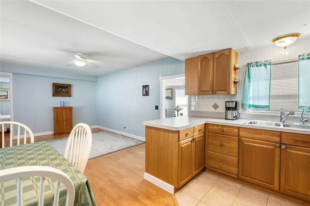 a kitchen with stainless steel appliances granite countertop a sink a stove a dining table and chairs