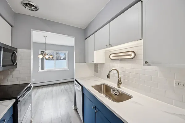 a kitchen with granite countertop a sink stove and cabinets