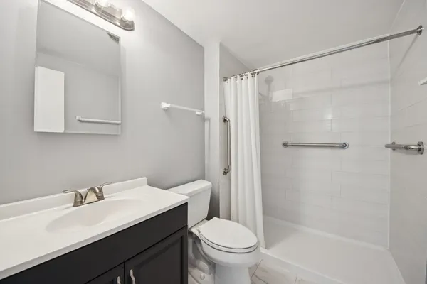 a bathroom with a sink toilet vanity and shower