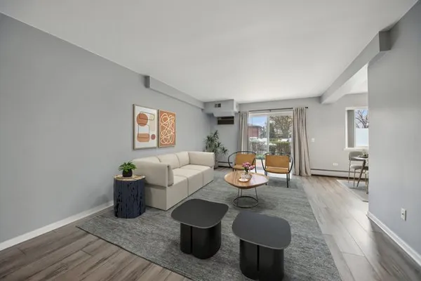 a living room with furniture a wooden floor and potted plant