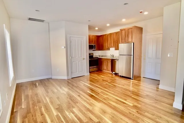 a view of kitchen with stainless steel appliances granite countertop a refrigerator and a sink