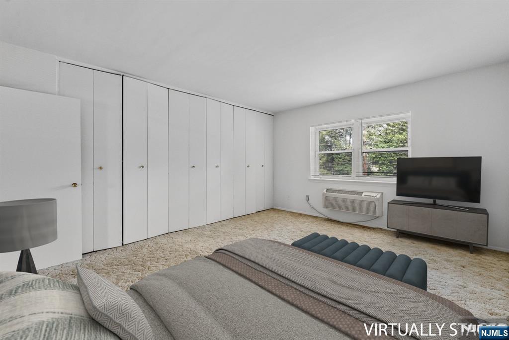 54 Westervelt Avenue, Unit B Tenafly, NJ 07670 - Photo 11 of 17 a bedroom with a bed and a flat screen tv