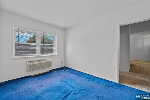 a view of an empty room with wooden floor and windows
