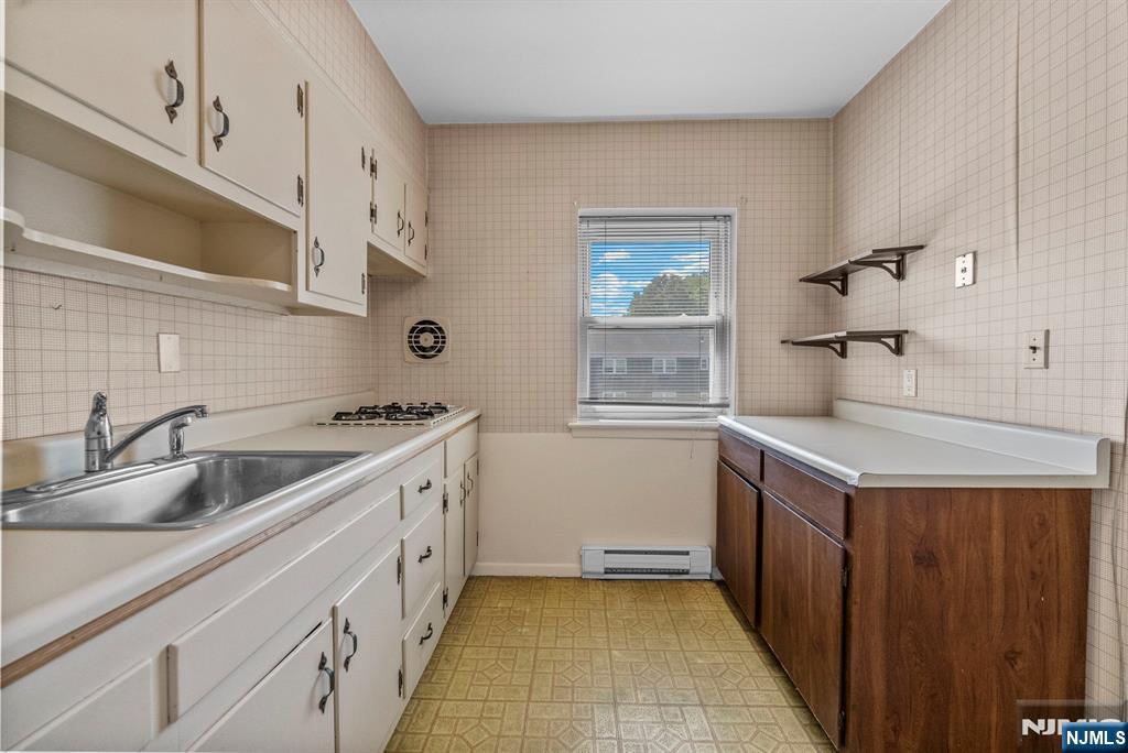 54 Westervelt Avenue, Unit B Tenafly, NJ 07670 - Photo 8 of 17 a kitchen with a sink stove and cabinets
