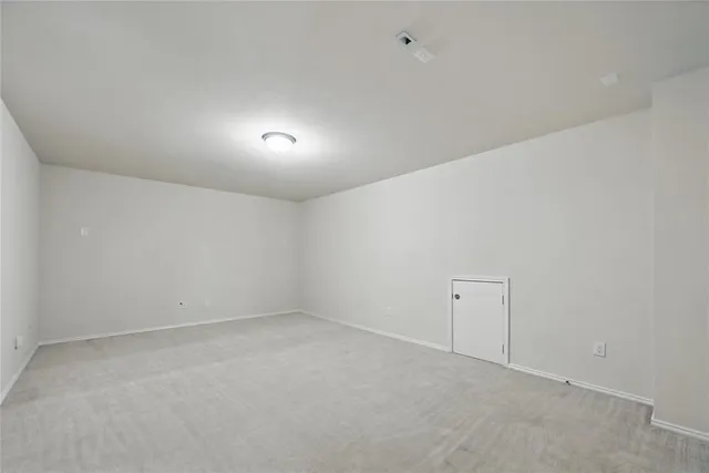an empty room with closet and a hallway