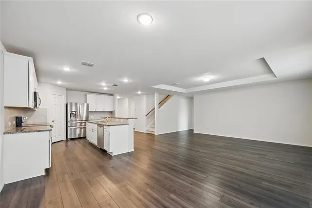 a view of a kitchen with a sink and wooden floor