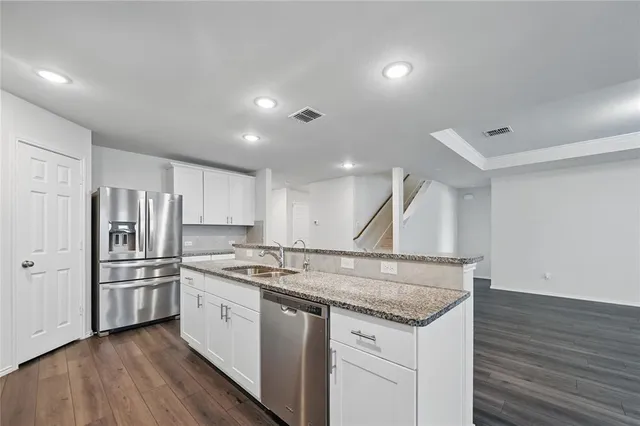a kitchen with stainless steel appliances granite countertop a sink stove and refrigerator