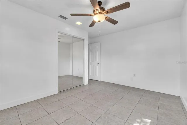 an empty room with fan and entryway