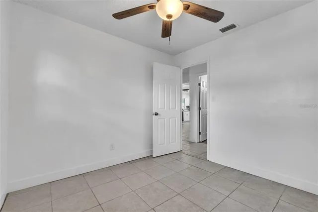 an empty room with chandelier fan