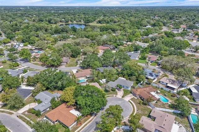 an aerial view of residential houses with outdoor space and trees