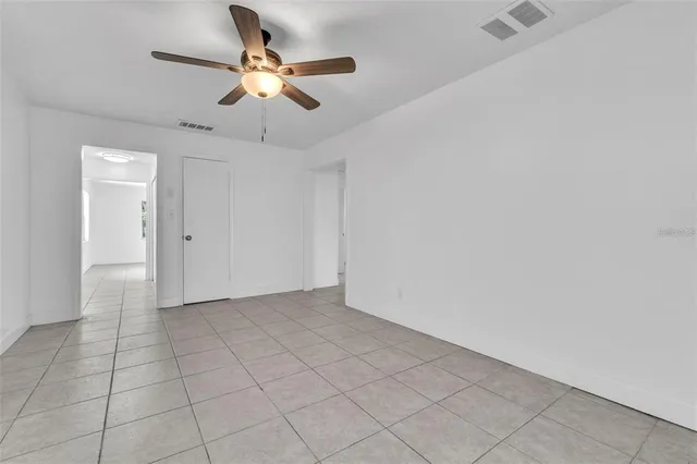 an empty room with fan and natural light