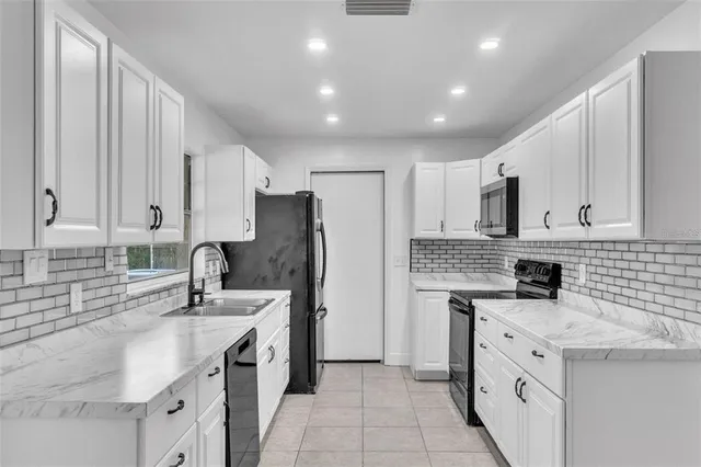 a kitchen with a sink stove a refrigerator and cabinets