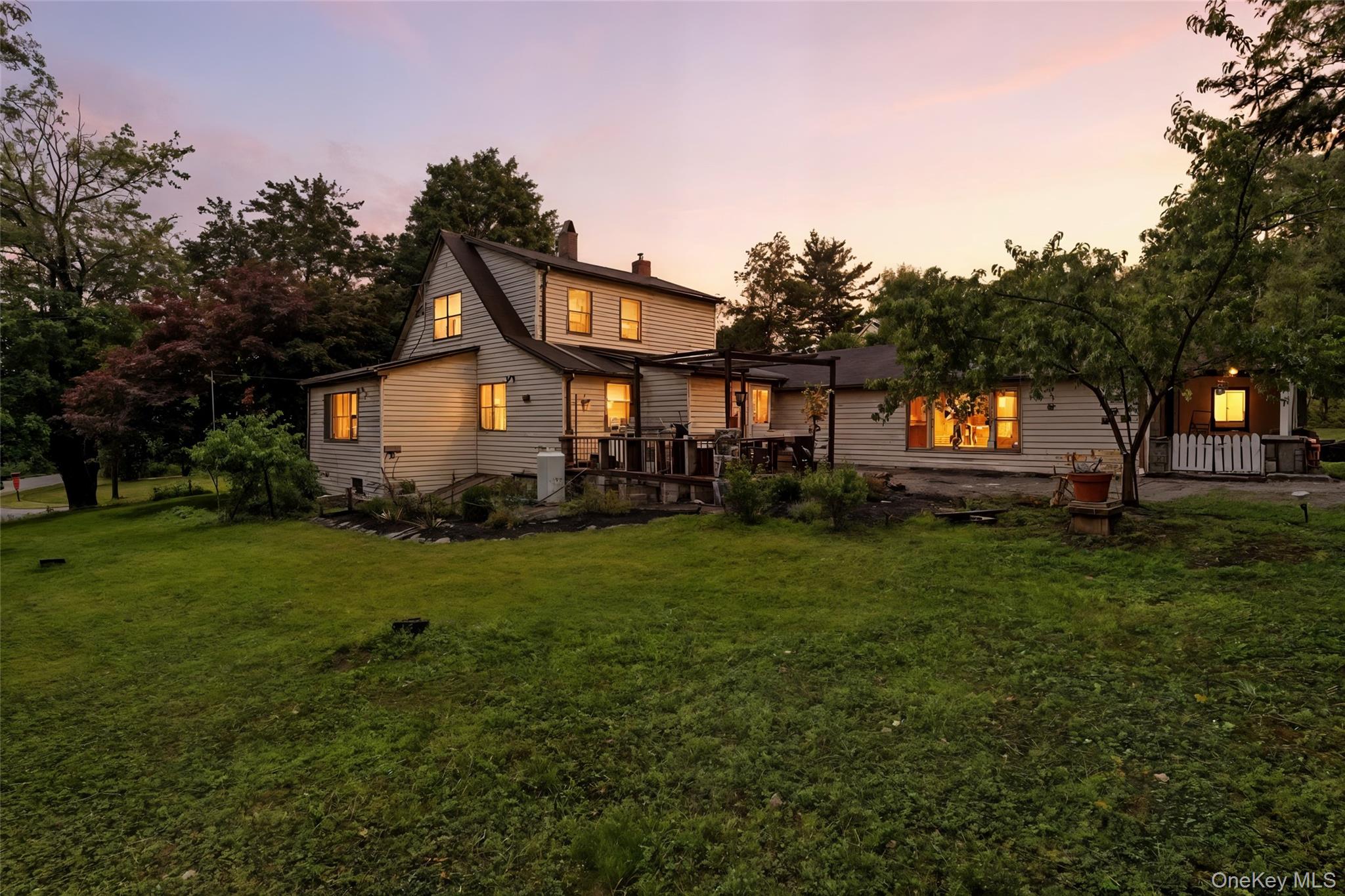 a front view of a house with a yard and trees