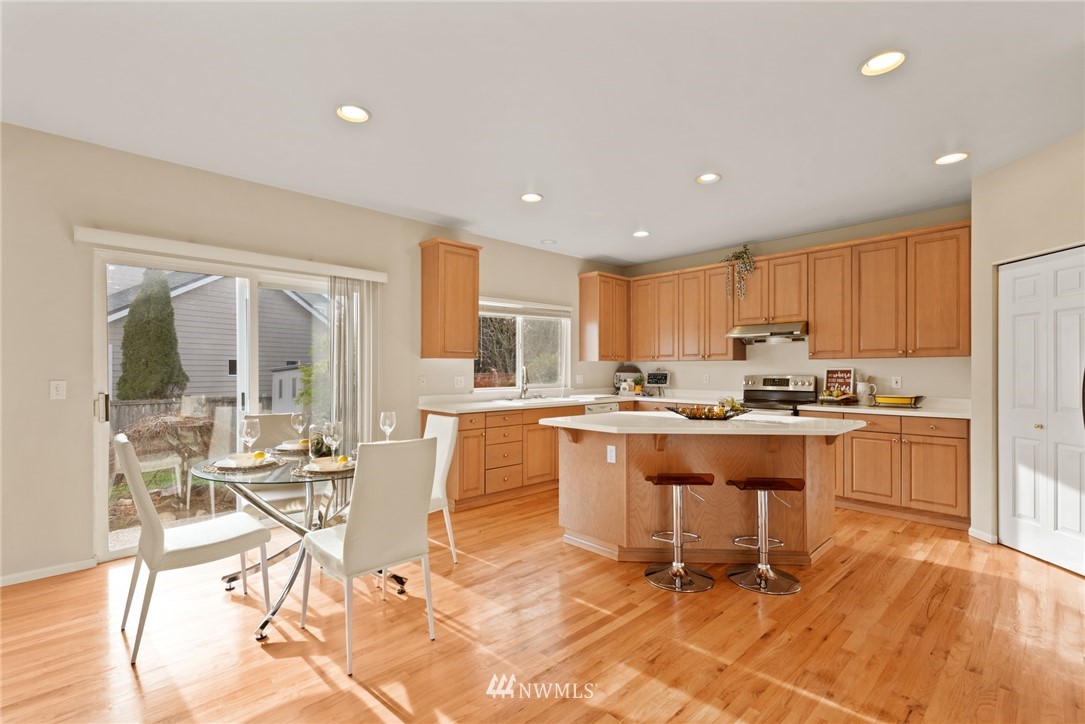 17567 Southeast 186th Way Renton, WA 98058 - Photo 7 of 28 a kitchen with a table chairs refrigerator and cabinets