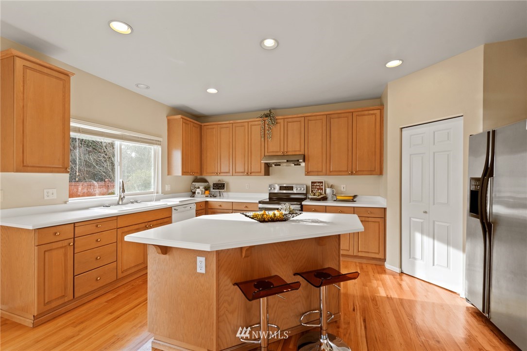 17567 Southeast 186th Way Renton, WA 98058 - Photo 8 of 28 a kitchen with stainless steel appliances granite countertop a sink a stove a refrigerator cabinets and a window
