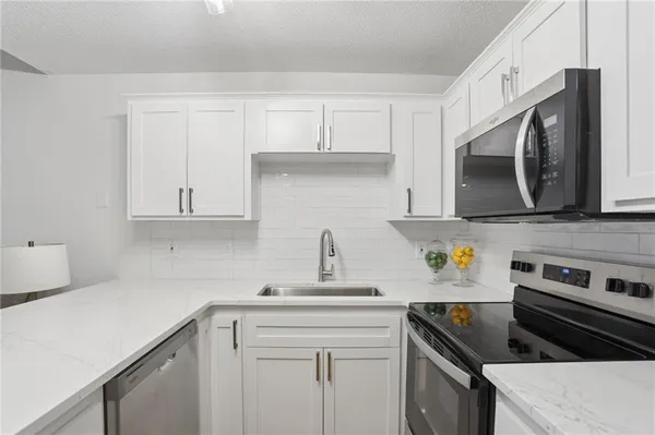 a kitchen with cabinets stainless steel appliances and a sink