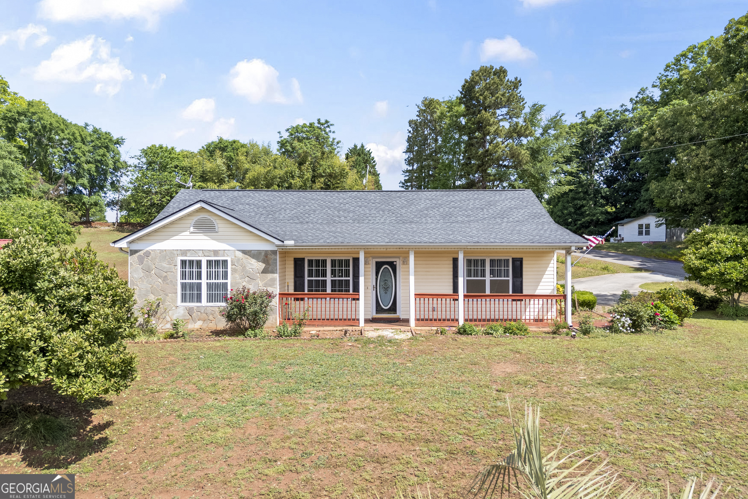 a front view of a house with a yard and trees