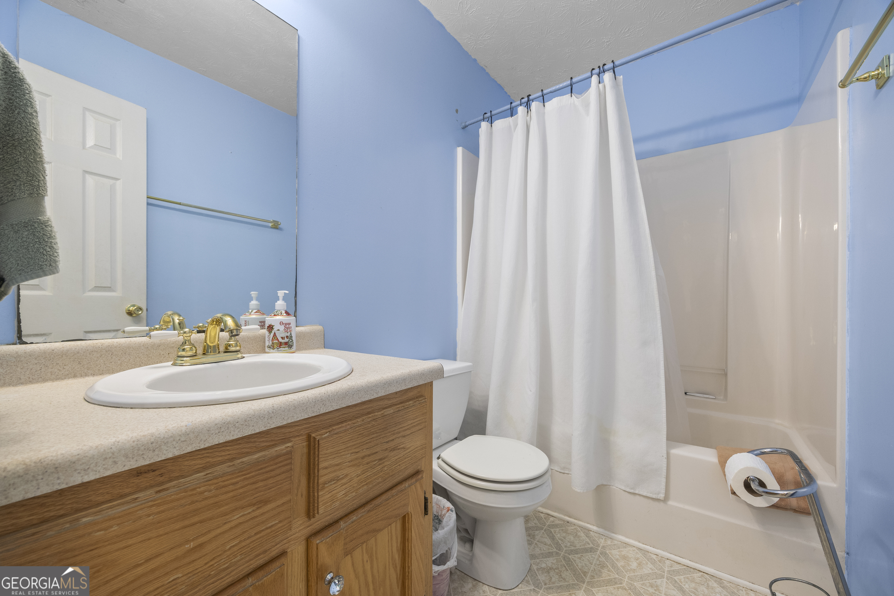 574 Mt Bethel Road Commerce, GA 30530 - Photo 44 of 64 a bathroom with a sink a toilet and shower curtain