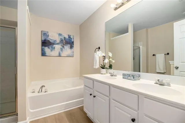 a bathroom with a tub a sink and mirror