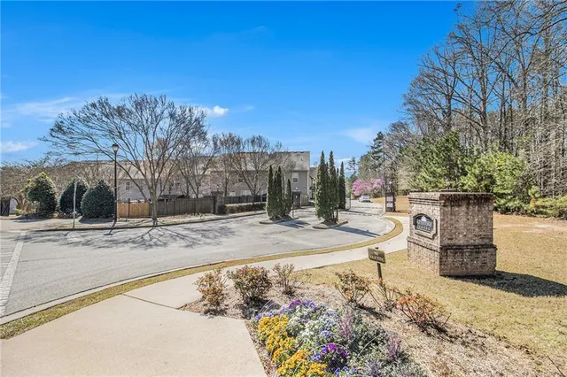 a view of a backyard that has plants and large trees