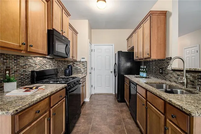 a kitchen with stainless steel appliances granite countertop a stove a sink dishwasher and a refrigerator