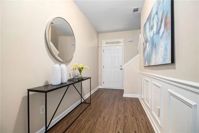 a view of a hallway with wooden floor and staircase