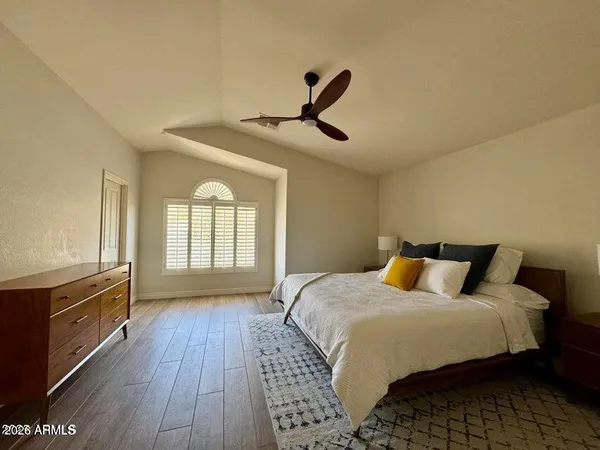 a bedroom with a bed and wooden floor