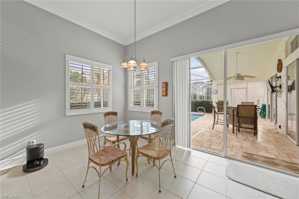 9057 Whitfield Drive Estero, FL 33928 - Photo 14 of 32 a dining room with furniture and floor to ceiling windows