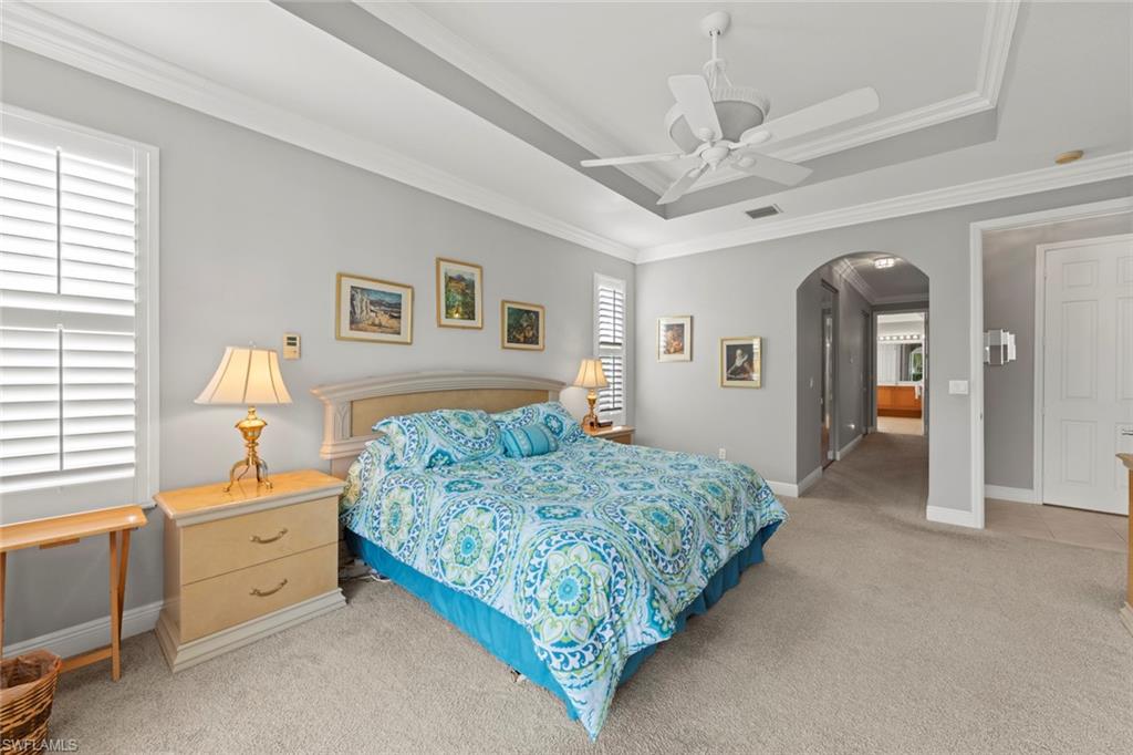 9057 Whitfield Drive Estero, FL 33928 - Photo 16 of 32 a spacious bedroom with a bed and a chandelier
