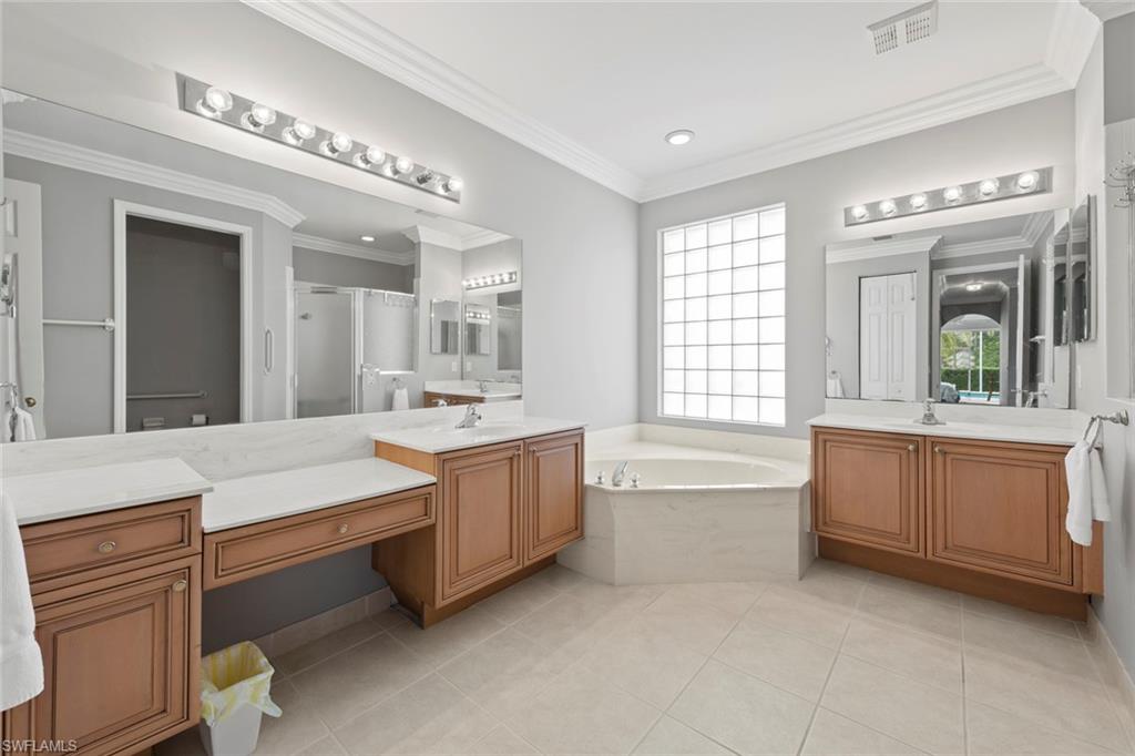 9057 Whitfield Drive Estero, FL 33928 - Photo 18 of 32 a large white bathroom with a large tub sink and vanity