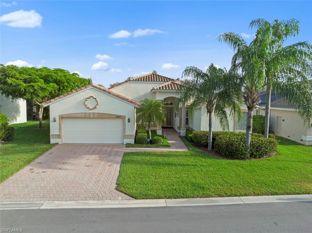 9057 Whitfield Drive Estero, FL 33928 - Photo 2 of 32 a front view of a house with a yard and garage