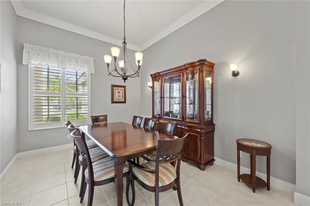 9057 Whitfield Drive Estero, FL 33928 - Photo 5 of 32 a dining room with furniture a chandelier and window
