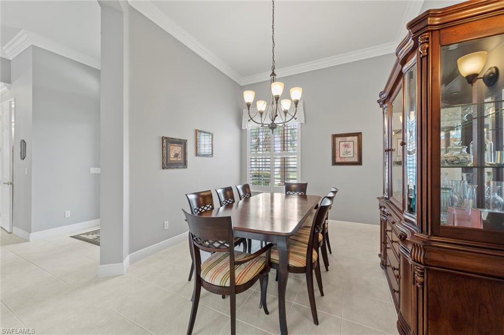 9057 Whitfield Drive Estero, FL 33928 - Photo 6 of 32 a dining room with furniture a chandelier and wooden floor