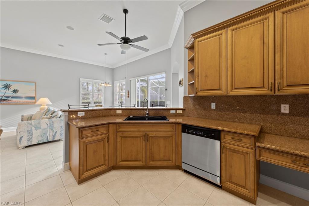 9057 Whitfield Drive Estero, FL 33928 - Photo 7 of 32 a kitchen with stainless steel appliances granite countertop a sink and cabinets