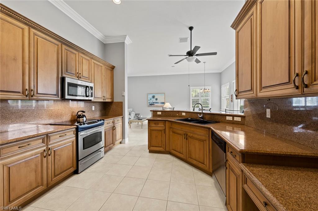 9057 Whitfield Drive Estero, FL 33928 - Photo 8 of 32 a kitchen with stainless steel appliances granite countertop a stove top oven a sink dishwasher and a microwave oven on the blue kitchen countertops