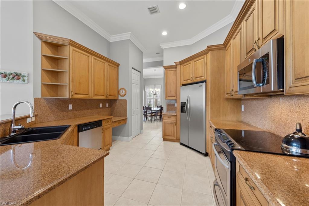 9057 Whitfield Drive Estero, FL 33928 - Photo 9 of 32 a kitchen with stainless steel appliances granite countertop a sink a stove and a refrigerator