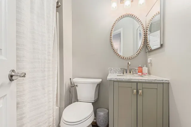 a bathroom with a toilet a sink and mirror
