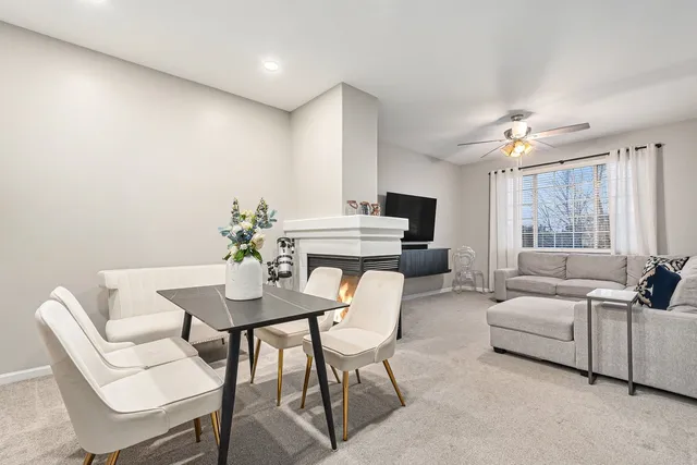 a living room with furniture a chandelier fan and a window