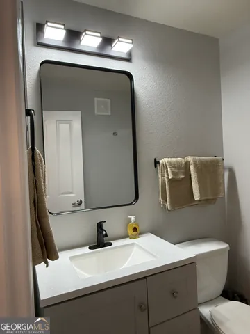 a bathroom with a toilet sink and mirror