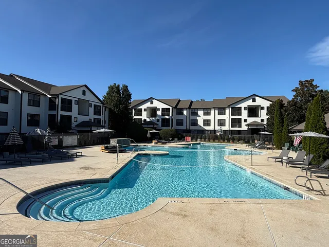 a view of a house with swimming pool and sitting area